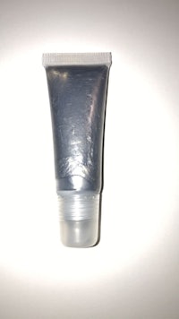 a tube of silver makeup on a white surface