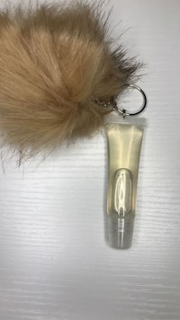 a bottle of lotion with a furry tail attached to it